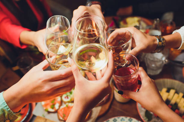 istock Human hands with glasses of red wine clinking them over served table. 1172084717