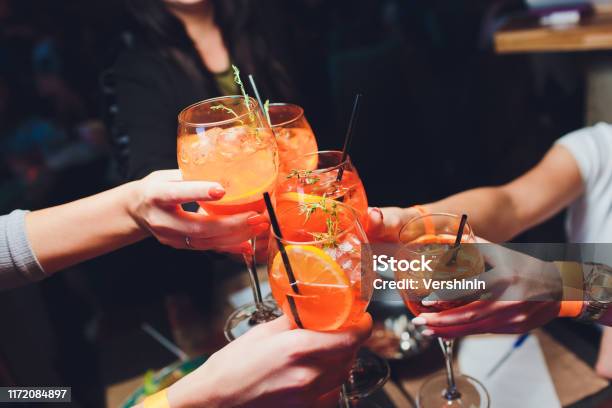 Women Raising A Glasses Of Spritz At The Dinner Table Stock Photo - Download Image Now