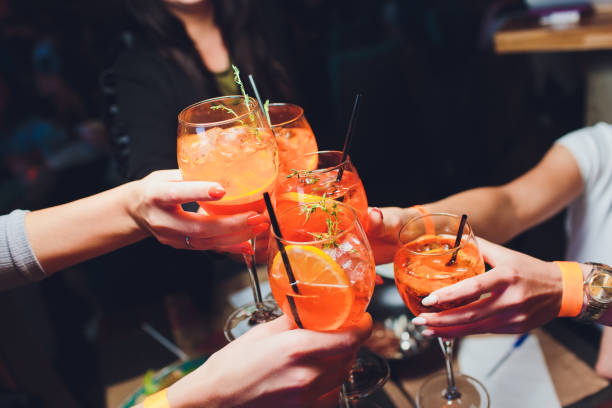 kobiety podnoszące kieliszki spritz przy stole. - drink alcohol summer celebration zdjęcia i obrazy z banku zdjęć