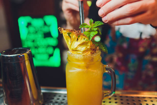 istock Bartender finished decorating his cocktail with mint and orange slice. 1172084919