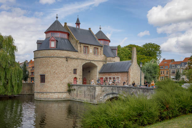 The Ezelpoort (Donkey's Gate) is one of the four remaining city gates in Bruges. It was built during the construction of the second ring of ramparts in 1297. Local people are passing the bridge.