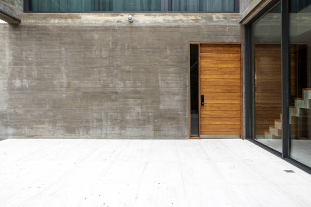 istock Wooden doors and bare cement walls and glass windows in modern room interior 1172108480