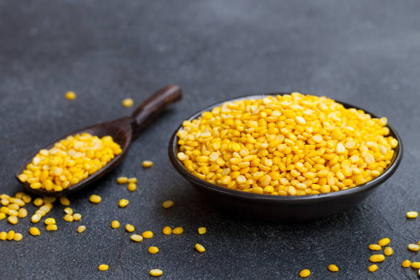 istock Yellow lentil in black bowl and scoop on slate background. Copy space. 1172114015