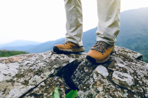 istock Successful woman hiker legs stand at mountain peak cliff edge 1172115461