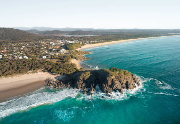 sunrise aerial of cabarita headland in new south wales, australia. beautiful sunrise light with waves on white sand beach. one of many favourite backpacker stop on road trip holiday. - cabarita beach imagens e fotografias de stock