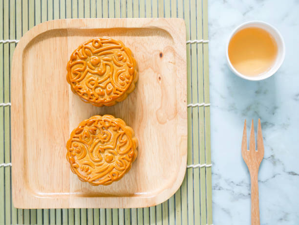 istock Mooncakes on a wooden plate with a cup of tea 1172120418
