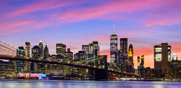 панорамный вид на манхэттен-сити скайлайн и бру�клинский мост в сумерках, нью-йорк, сша - east river фотографии стоковые фото и изображения