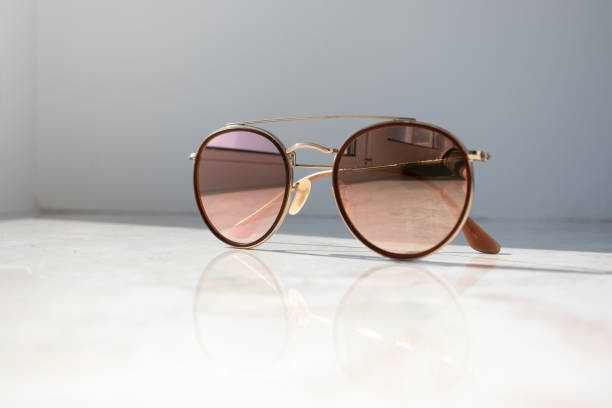 istock Stylish light brown sunglasses on white natural surface 1172130060