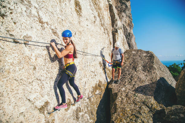istock Woman and man climbing mountain. 1172130487