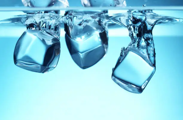 Group of ice cubes falling in water. Refreshment and drink concept