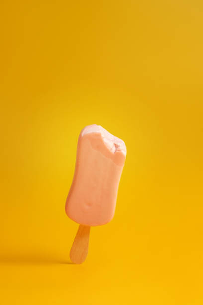 istock pink ice cream popsicle on yellow background bitten off a piece 1172133353