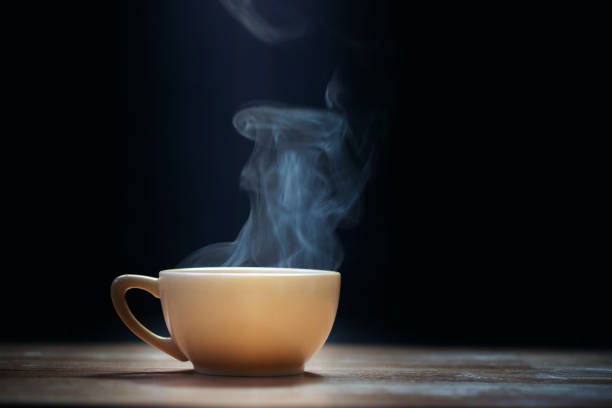 istock Cup of coffee with steam on black background 1172133517