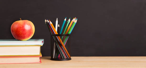 istock School books, apple and pencils over chalkboard background 1172135497