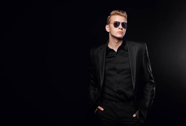 istock young man with black glasses in black jacket on black background 1172135519
