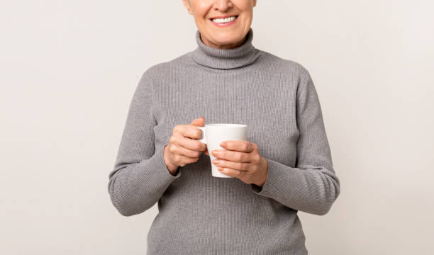 istock Smiling senior lady holding cup with hot coffee 1172135726