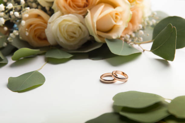 istock Wedding rings with roses on white background 1172136597