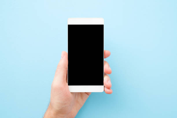 istock Young man hand holding smartphone on pastel blue background. Empty place for text on black screen. Close up. Top view. 1172136863