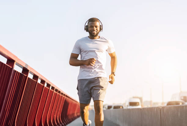 istock Cheerful black guy enjoying jogging by the city 1172137151