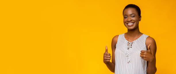 istock Cheerful black woman showing thumbs up, empty space 1172137795