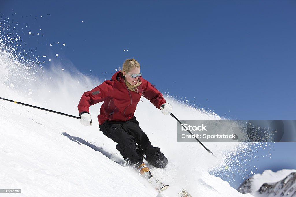 Sciatore femminile contro il cielo blu - Foto stock royalty-free di Sci - Sci e snowboard