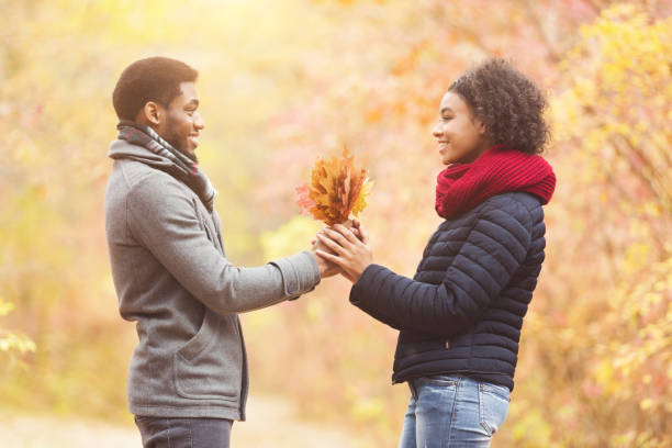 istock Romantic man giving girlfriend bunch of maple leaves 1172137830