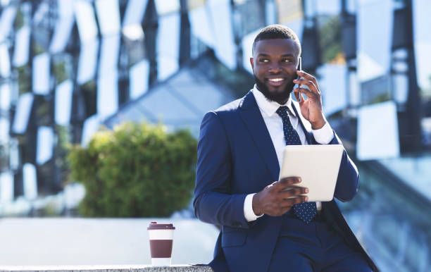 istock Businessman Talking On Phone Holding Tablet During Coffee Break Outside 1172137968