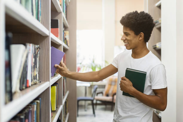 istock African american young guy choosing books at campus library 1172138514