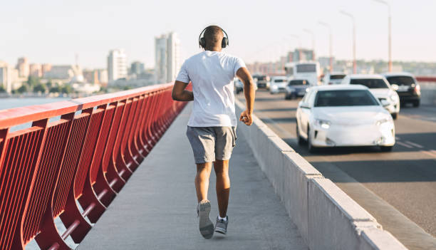 istock Well fit african american guy running down the bridge 1172139548