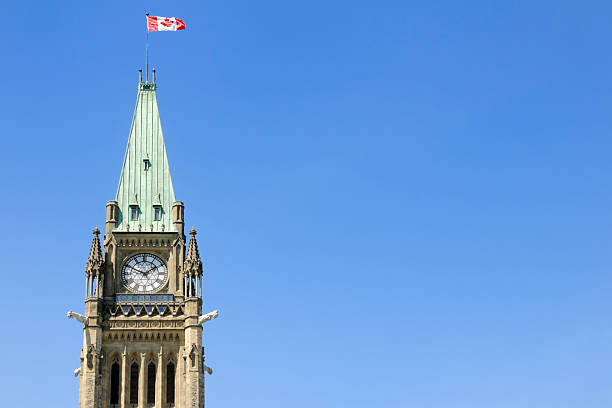 The peace tower with a Canadian flag waving in the air The Peace Tower in Ottawa, Ontario, Canada. Adobe RGB color profile. parliament building stock pictures, royalty-free photos & images
