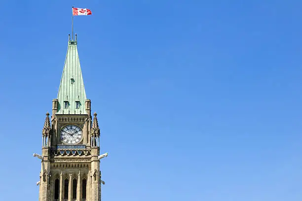 Photo of The peace tower with a Canadian flag waving in the air