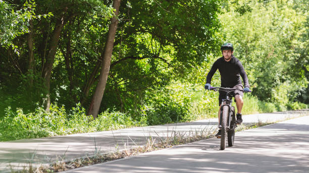 istock Focused professional cyclist riding down park road 1172140814