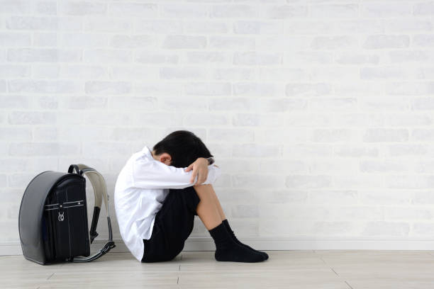 niño sentado solo en la sala de estar - mental abuse fotografías e imágenes de stock