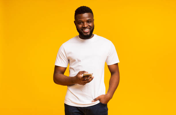 istock Smiling black man holding phone and looking to camera 1172141190