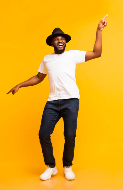 istock Cheerful black man dancing and pointing index fingers aside 1172141878