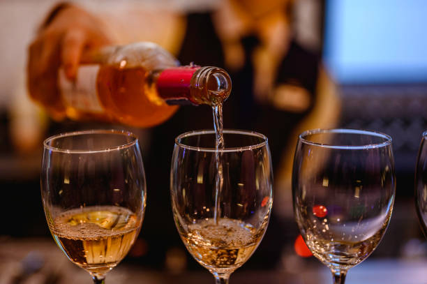 istock Pouring glasses of white wine from a bottle. 1172143139