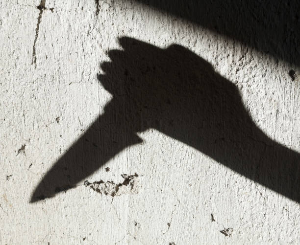 Shadow of the hand holding a knife Shadow of the hand holding a big sharp knife. Murderer, killer or robber with a knife. Criminal. Crime. Horror scene. knife crime photos stock pictures, royalty-free photos & images