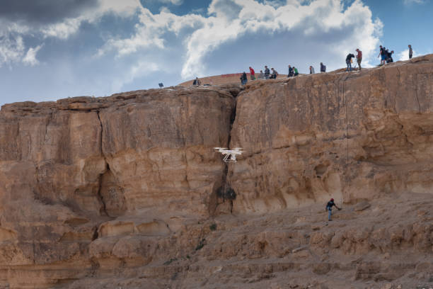 istock Quadcopter, multicopter, drone, copter copter makes photo climbers people. Modern video and aerial photography 1172144823