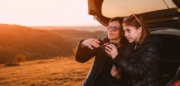 istock Mother and daughter camping on hill and using binoculars 1172145200