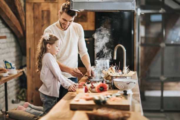 istock Happy father and daughter cooking lunch in the kitchen. 1172145290