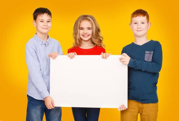 istock School children showing blank placard board for text 1172146896