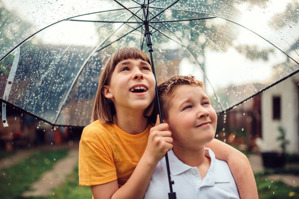 istock Brother and sister enjoying rain 1172146975