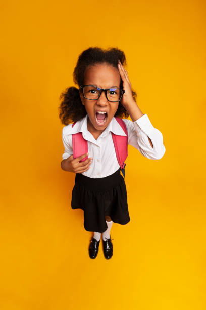 istock Little School Girl Shouting Touching Head On Yellow Background 1172147072
