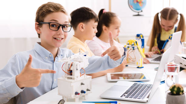 istock Smart boy showing his robot, studying in classroom 1172147447