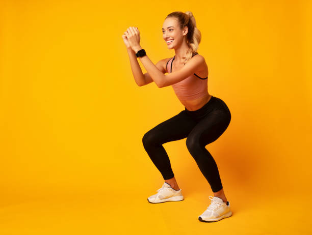 istock Millennial Girl Doing Deep Squat Exercise On Yellow Background 1172149081