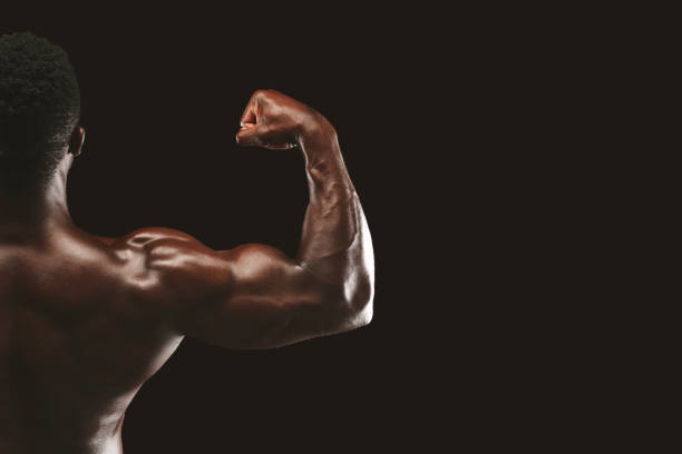istock Strong biceps of afro bodybuilder on black background 1172149143