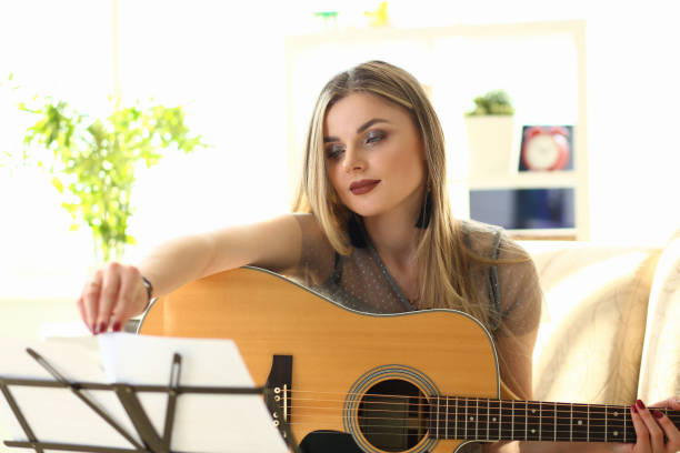 istock Woman Practice Acoustic Guitar Playing at Home 1172149482