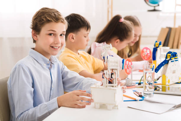 istock Schoolboy creating robot at lab, smiling to camera 1172150239