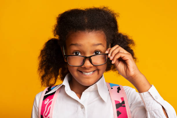 istock Black Elementary Schoolgirl Looking Over Glasses At Camera, Studio Shot 1172150242