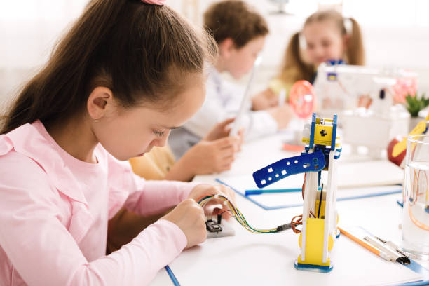 istock Girl working with wires and circuits on robotics project 1172150277