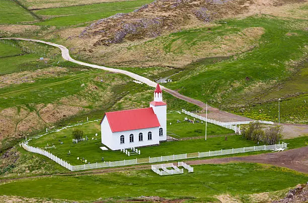 A small church surrounded with green meadows.